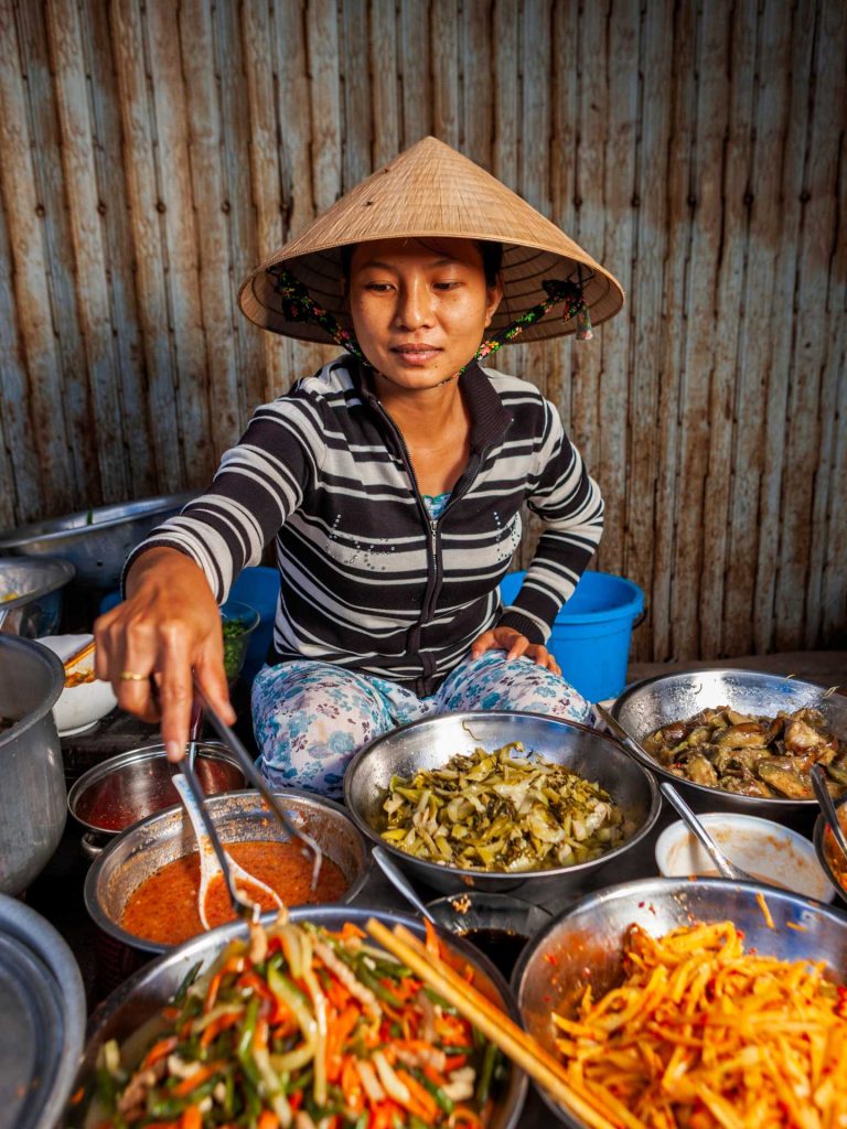 Young Vietnamese woman selling food on local market